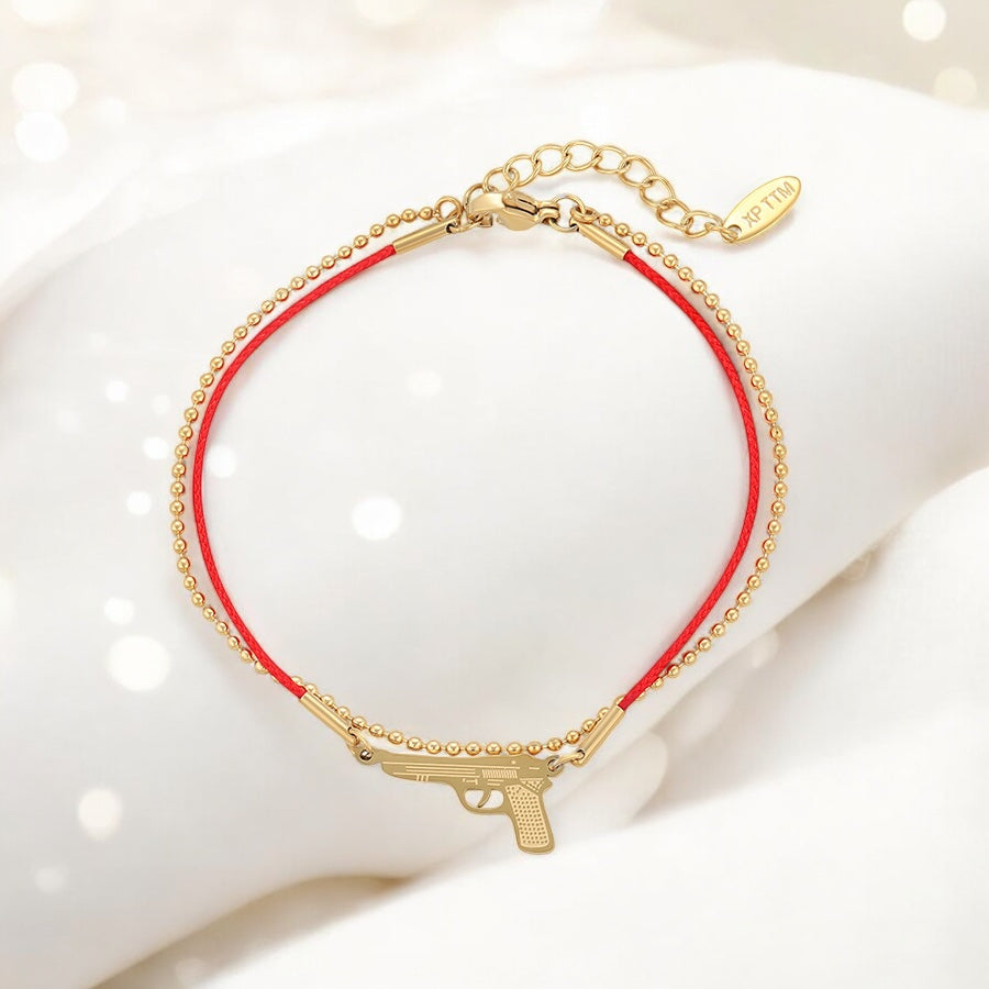 Позлатена гривна с червен конец и пистолет